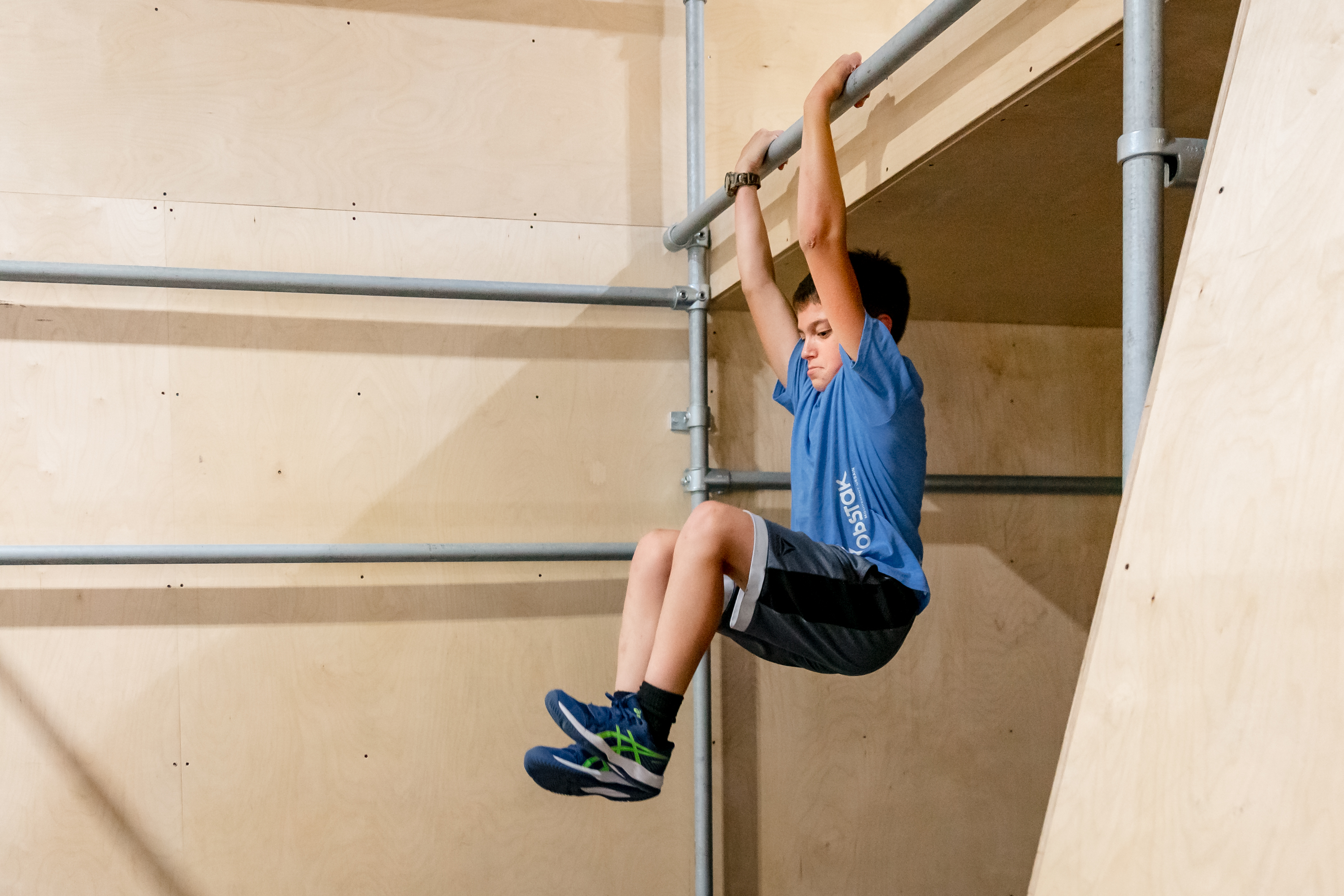Josh, jeune traceur chez Obstak, ex&eacute;cute une descente contr&ocirc;l&eacute;e sur une barre, d&eacute;montrant ma&icirc;trise et gestion du mouvement.